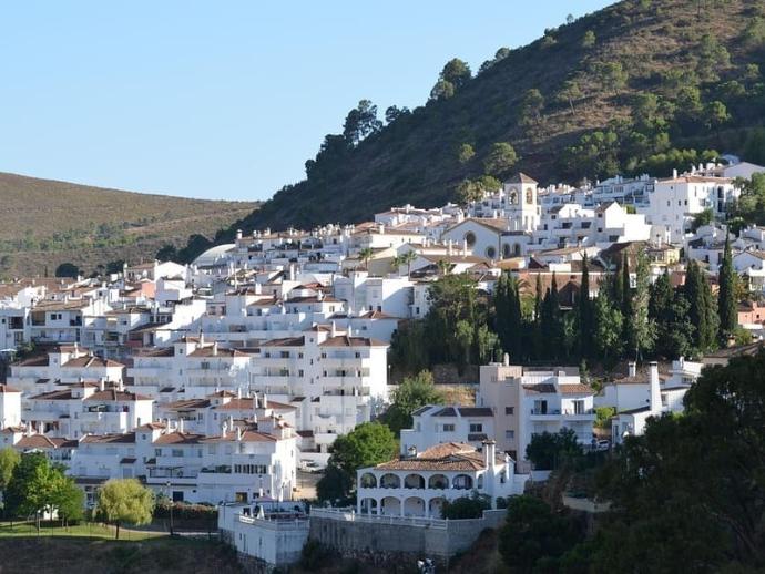 Vista panorámica del pueblo blanco de Benahavís en la Costa del Sol, destacando su arquitectura tradicional andaluza y entorno natural de montaña.