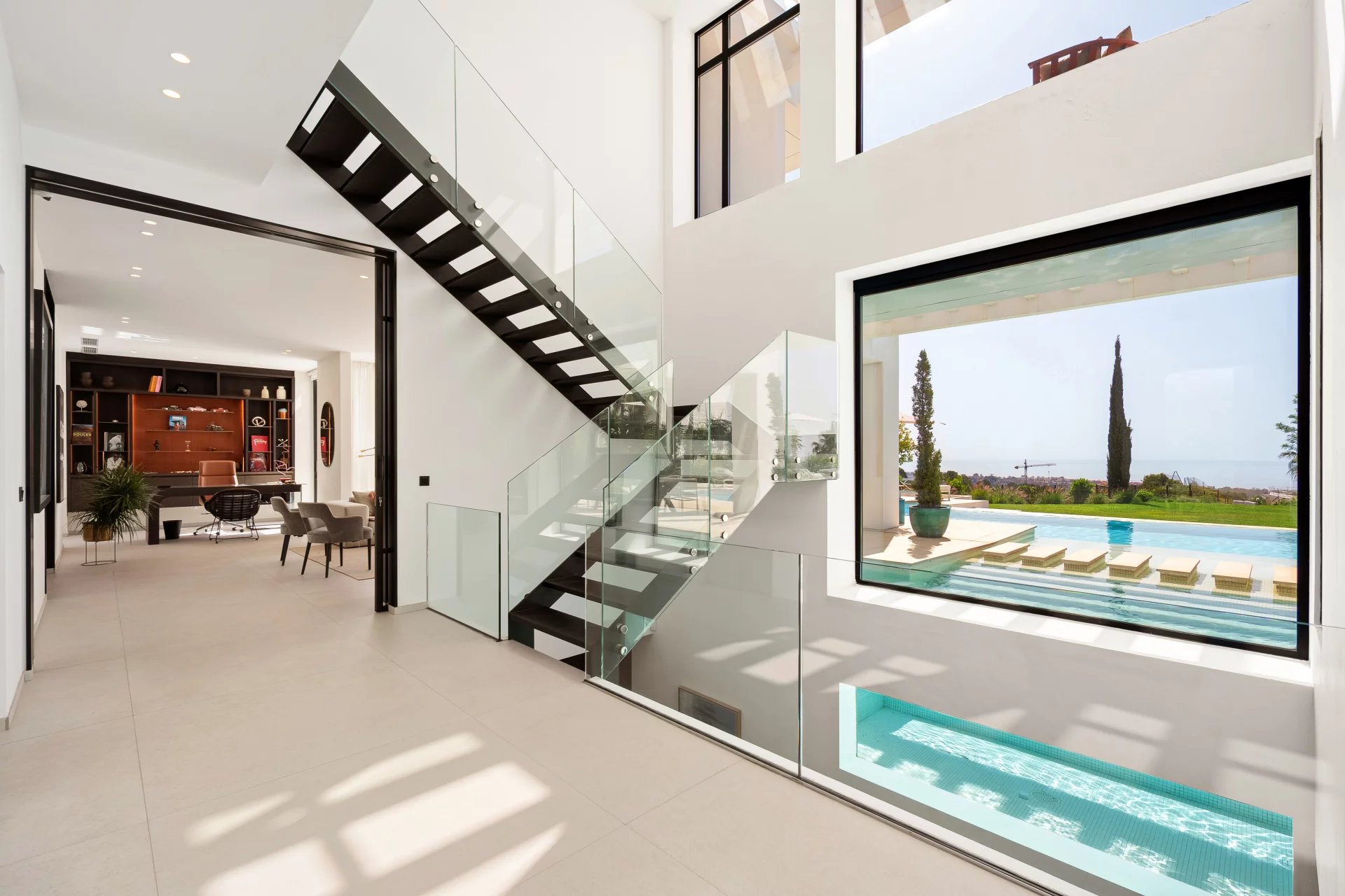 Intérieur de villa contemporaine avec grande baie vitrée sur la piscine